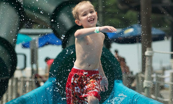 young child splashing on water slide at wild water & wheels