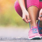 Woman lacing up tennis shoes